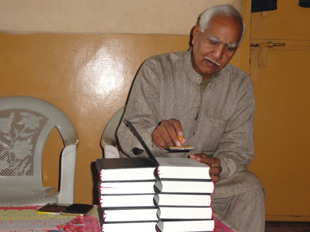 Urdu Bible Distribution Program. Mr. Arif is stamping the Bibles as a gift from Calvary Chapel Pakistan before presenting them. 
